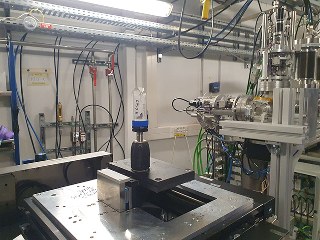 Une tablette de plomb enroulée, placée dans un tube sur la table de tomographie dans la cabane d’expériences de PSICHÉ